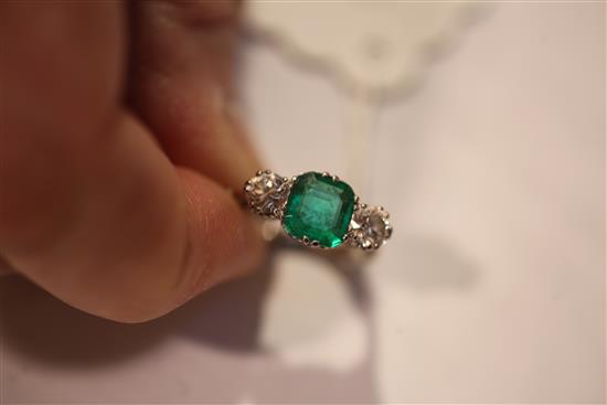 A mid 20th century 18ct white gold, emerald and diamond three stone ring, size K.